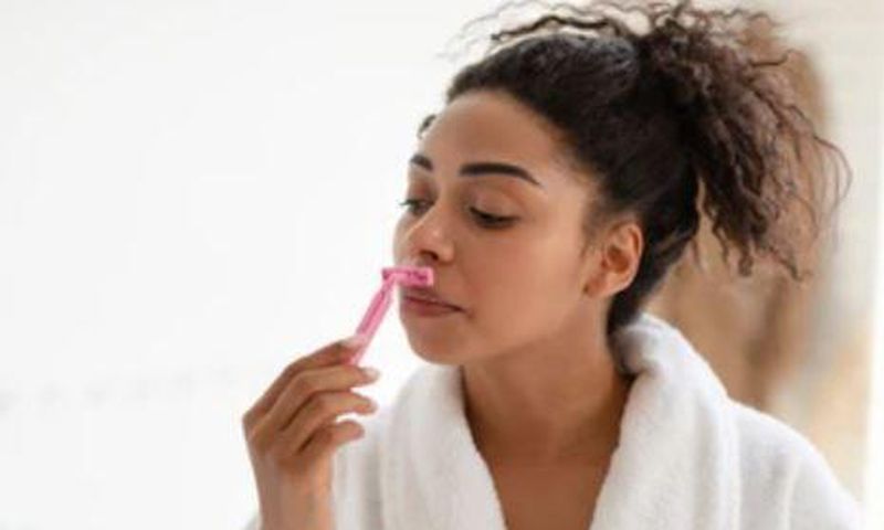 Lady shaving her face
