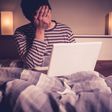 Sad man in bed with laptop