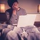 Sad man in bed with laptop