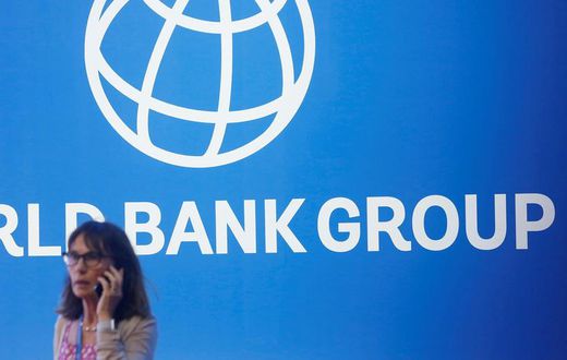 FILE PHOTO: A participant stands near a logo of World Bank at the International Monetary Fund - World Bank Annual Meeting 2018 in Nusa DuaReuters