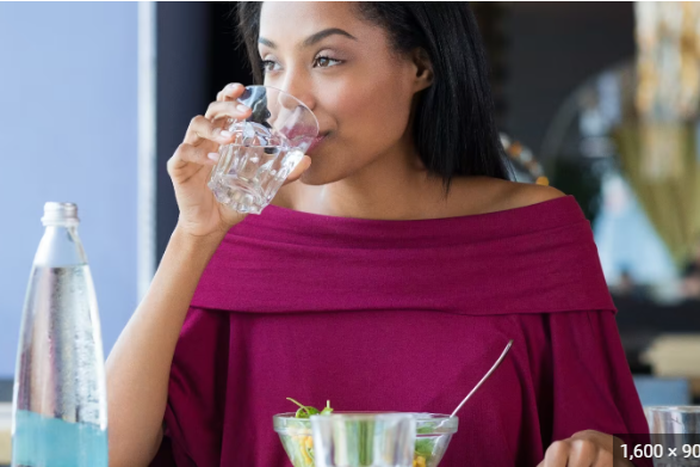 Lady drinking while eating