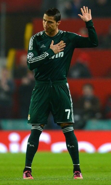 Friendly fire: Cristiano Ronaldo raises a hand in apology after scoring the winner for Real Madrid against Manchester United in the Champions League last 16 in 2013