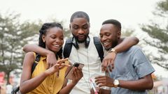 A group of black people checking out a phone [Freepik]