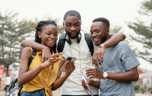 A group of black people checking out a phone [Freepik]