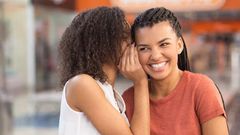 Black girl whispering secret to smiling girlfriend [Freepik]