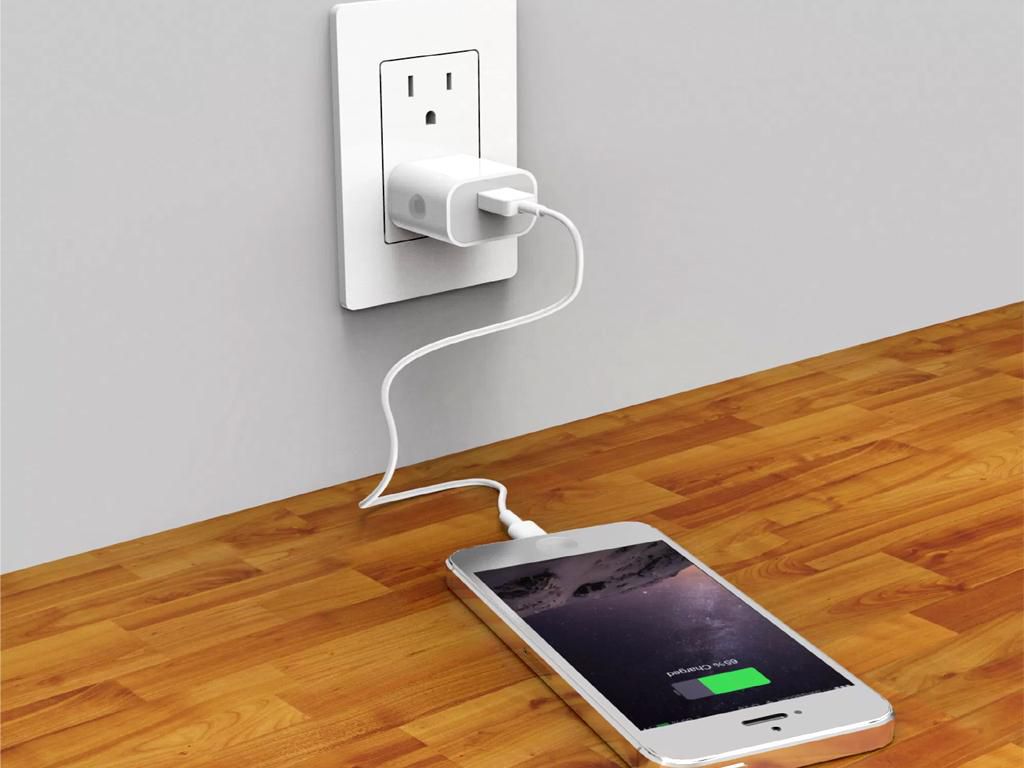An apple Iphone plugged in to charge