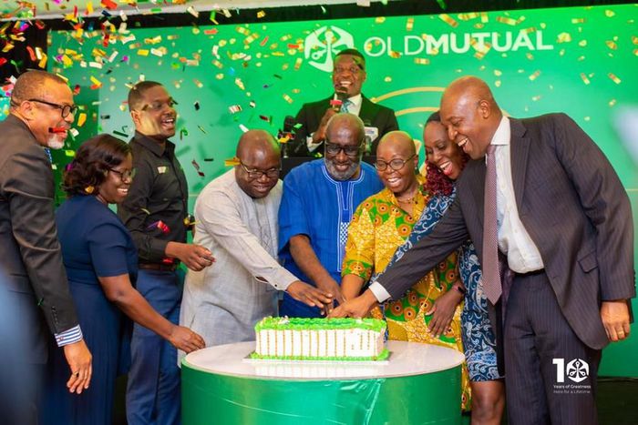 Some management executives, board members and dignitaries cutting the 10th anniversary launch cake of Old Mutual Ghana