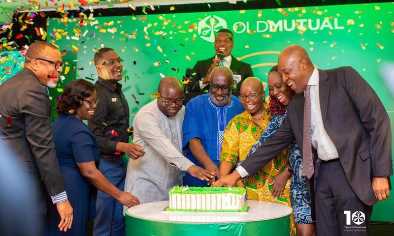 Some management executives, board members and dignitaries cutting the 10th anniversary launch cake of Old Mutual Ghana