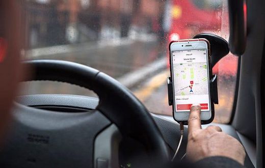 A driver uses the Uber Technologies Inc. ride-hailing service smartphone app to complete passenger drop-off in this arranged photograph in London, U.K., on Friday, Dec. 22, 2017. Uber will be regulated in European Union countries as a transport company...