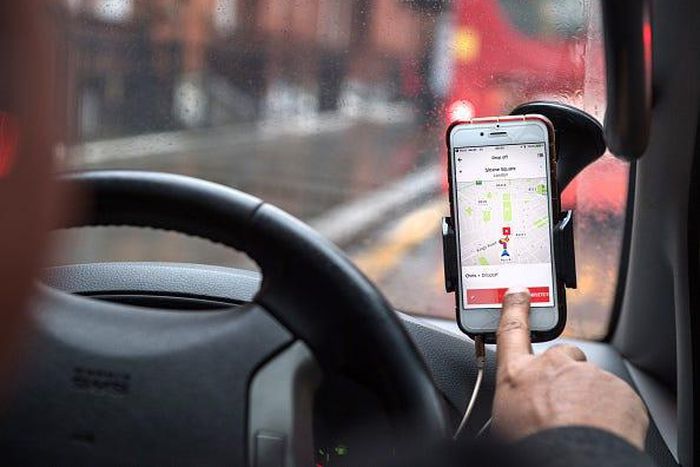 A driver uses the Uber Technologies Inc. ride-hailing service smartphone app to complete passenger drop-off in this arranged photograph in London, U.K., on Friday, Dec. 22, 2017. Uber will be regulated in European Union countries as a transport company...