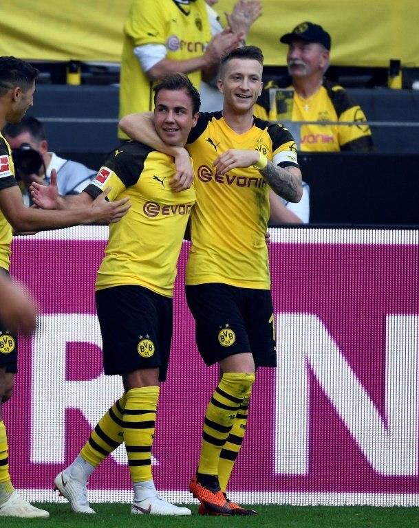 Mario Goetze and Borussia Dortmund captain Marco Reus celebrate their stunning 4-3 win over Augsburg