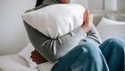 Unrecognisable woman embracing a pillow in a bedroom [Image Credit: Alex Green]