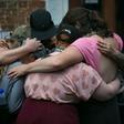 Mourners embrace next to a makeshift memorial to Heather Heyer in Charlottesville, Virginia, on the one year anniversary of her death at the hands of a white supremacist in a speeding car