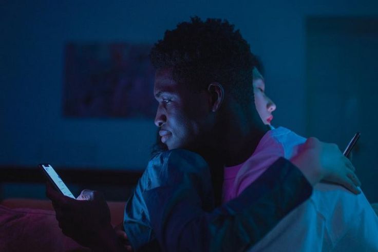 Couple using their phones while hugging [Photo: Cottonbro Studio]