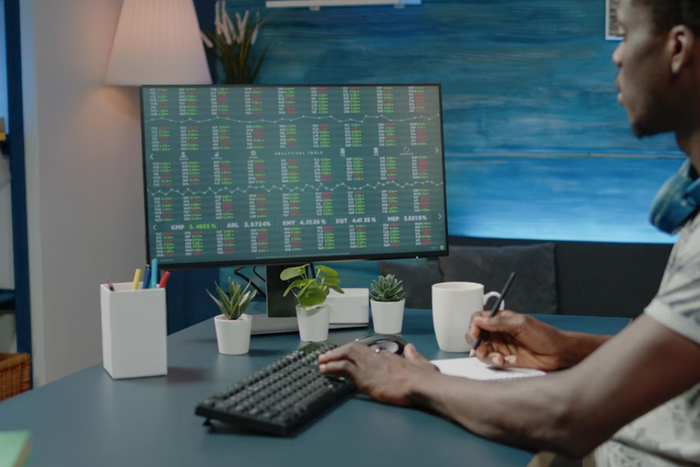 Business man analyzing stock market data charts and taking notes