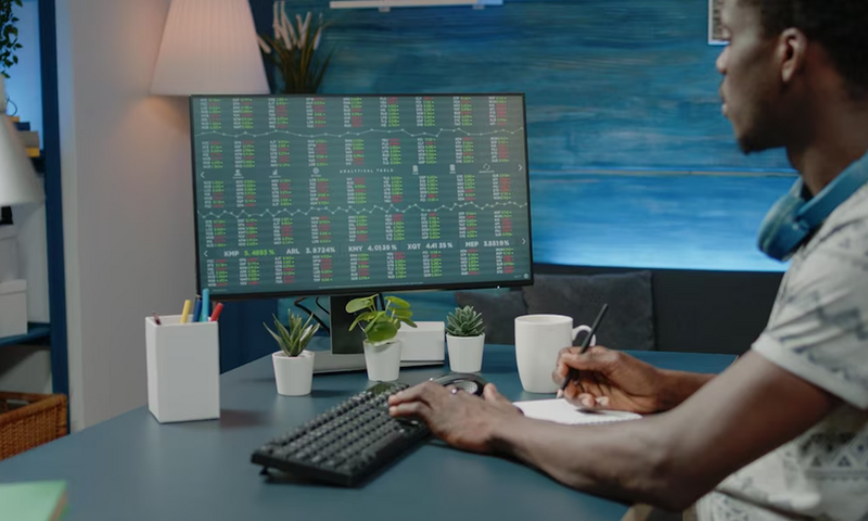 Business man analyzing stock market data charts and taking notes