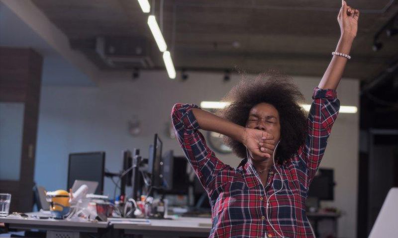 woman yawning at work tired