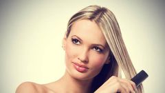 Woman using hair straightener