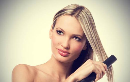 Woman using hair straightener
