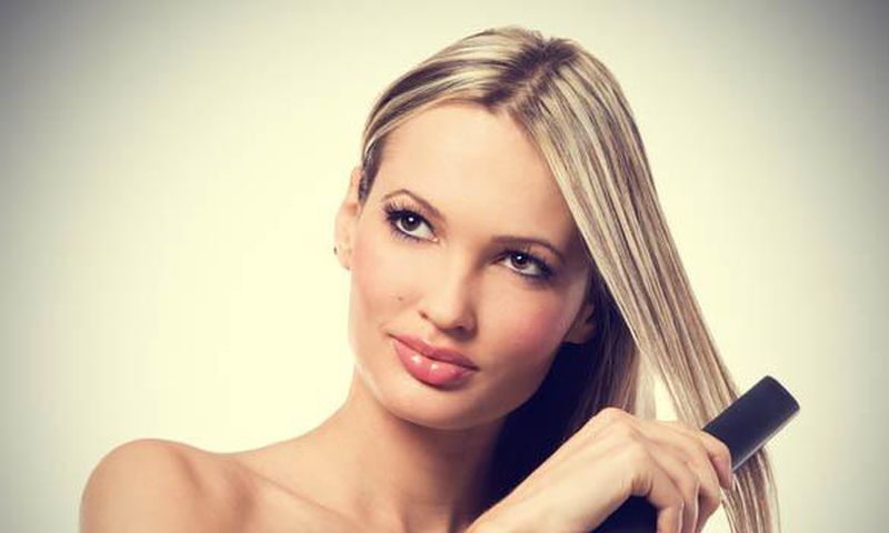 Woman using hair straightener