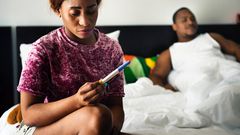 Woman holding pregnancy test(Rawpixel)