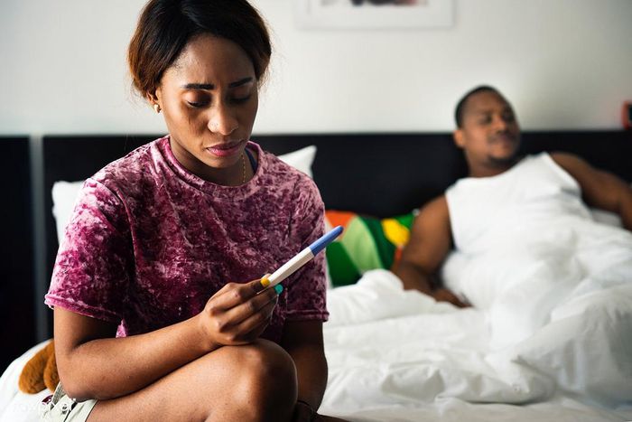 Woman holding pregnancy test(Rawpixel)