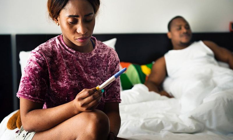 Woman holding pregnancy test(Rawpixel)