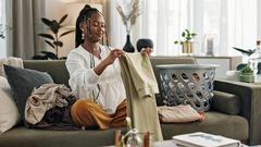 Young lady folding clothes in her apartment