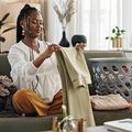 Young lady folding clothes in her apartment