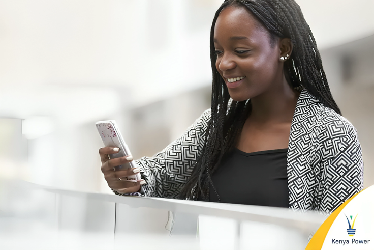 A lady using her phone to buy Kenya Power tokens