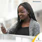 A lady using her phone to buy Kenya Power tokens