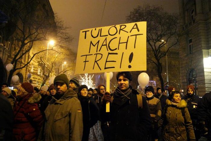 A protester holds a placard, reading 'Overtime sets you free' referring to the German phrase meaning "work sets you free" used at the entrance of the Auschwitz concentration camp, at a protest march against Hungary's new labour reform law