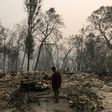 Jhonathan Clark walks in what was his house, destroyed by the Camp Fire, in Paradise -- his brother is among the missing