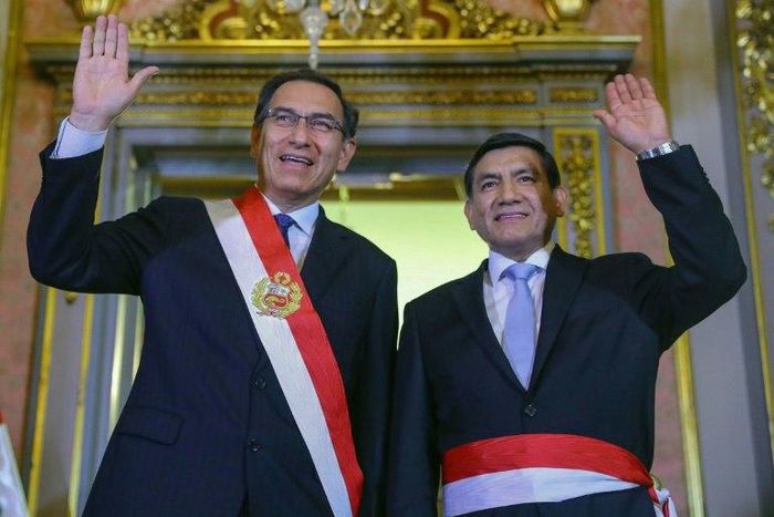 Handout picture released by the Peruvian presidency press office of President Martin Vizcarra (L) and newly appointed Interior Minister Carlos Moran, waving during a swearing-in ceremony at government headquarters in Lima on October 19, 2018.