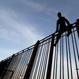 A Moroccan young boy climbs a fence in the port of the Spanish enclave of Melilla bordering Morocco on May 16, 2017.Midnight in Melilla and hidden near the harbor, nine-year-old Wahib is one of many children willing to do the "riski": take all the risk...