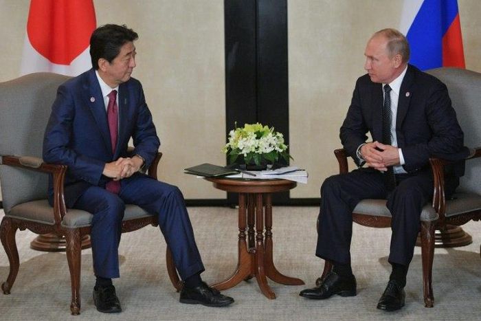 Japanese Prime Minister Shinzo Abe (L) told Russian President Vladimir Putin he was willing to discuss a peace treaty between the two countries, which are still technically at war