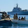 Navy personnel on routine patrol searching a boat on the sea