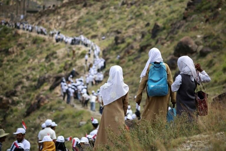 Yemenis form a human chain to pass food aid, supplied by the UAE Red Crescent, to mountainous towns on the outskirts of the city of Taiz on October 16, 2018