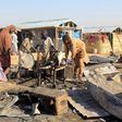 Children try to salvage items from a hut burnt in an attack by Boko Haram