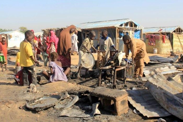 Children try to salvage items from a hut burnt in an attack by Boko Haram