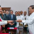 Former Sri Lankan president Mahinda Rajapakse, left, is sworn is as prime minister by President Maithripala Sirisena
