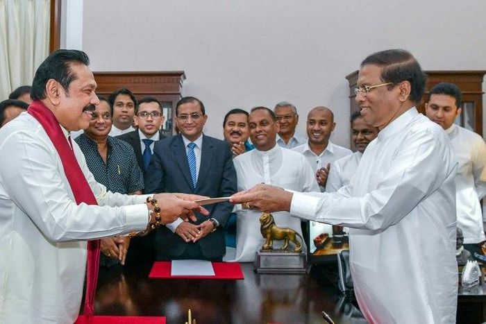Former Sri Lankan president Mahinda Rajapakse, left, is sworn is as prime minister by President Maithripala Sirisena