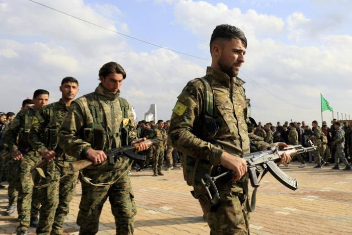 Members of the People's Protection Units (YPG) attend the funeral of fellow Kurdish fighters who were killed in combat against Islamic State (IS) group in Deir Ezzor, on March 3, 2018, in Qamishli
