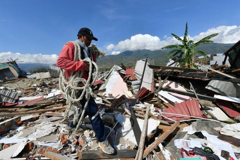 Sarjono, 50, who lost his home, searches the debris in hopes of salvaging his car in the hard-hit area of Balaroa