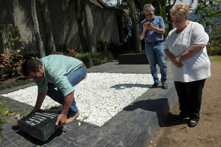 The sister of the Colombian drug lord Pablo Escobar, Luz Maria Escobar (R), visits his tomb at the Montesacro cemetery in Medellin