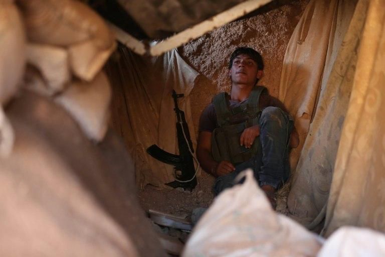 A rebel fighter takes position in a trench in the area of Al-Eis in northern Syria on October 7, 2018