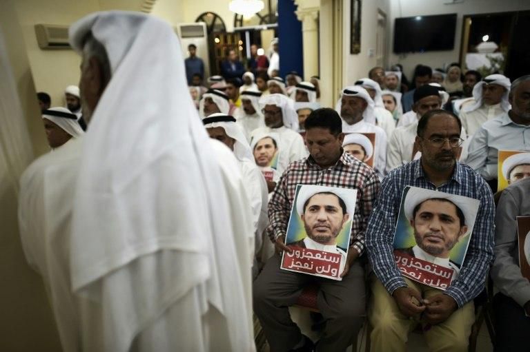 Bahraini men hold placards bearing the portrait of Sheikh Ali Salman, head of the Shiite opposition movement Al-Wefaq, during a protest against his arrest on May 29, 2016