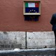 A man stares at a street-art installation in Rome inspired by Banksy and Italy's budget dispute with Brussels