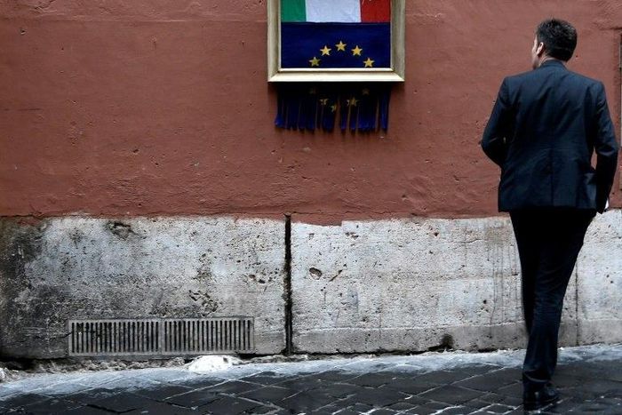 A man stares at a street-art installation in Rome inspired by Banksy and Italy's budget dispute with Brussels