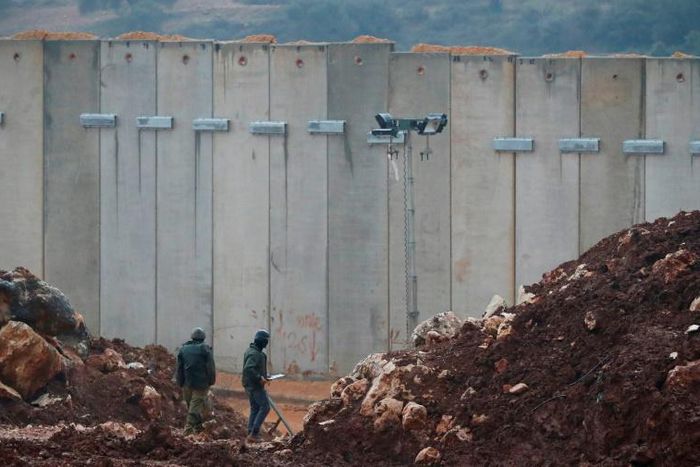 Israeli soldiers stand bye the concrete barrier erected along the border with Lebanon near the northern Israeli town of Metula: a Un investigation said two tunnels dug by Hezbollah stretched beneath the border line and into Israeli territory